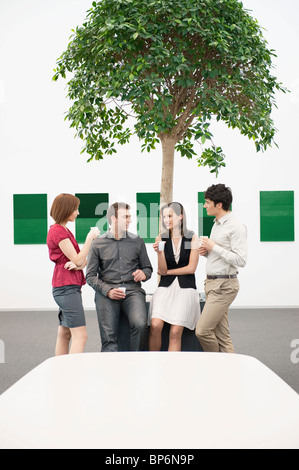Business executives talking to each other in a conference room during a coffee break Stock Photo