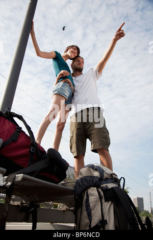 A young couple having fun while waiting on a train platform Stock Photo