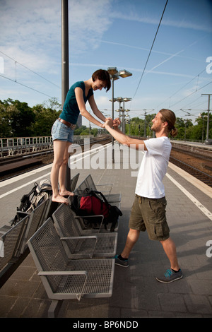 A young couple having fun while waiting on a train platform Stock Photo