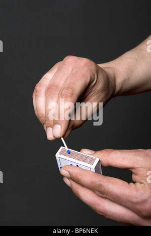 Detail of a man lighting a match Stock Photo