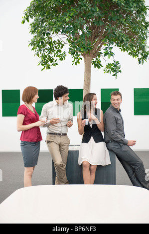 Business executives talking to each other in a conference room during a coffee break Stock Photo
