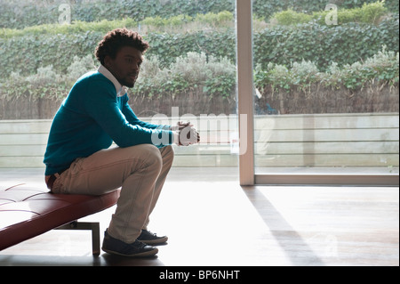Man sitting on a couch and thinking Stock Photo