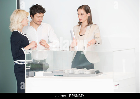 Man with two women near an architectural model Stock Photo