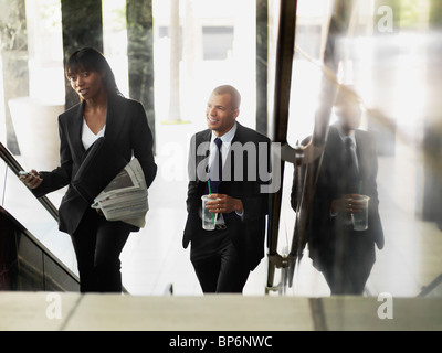 A businesswoman and businessman walking up stairs Stock Photo