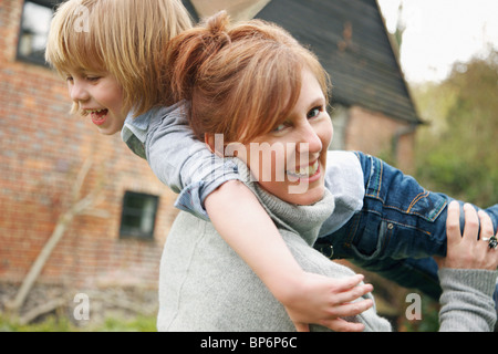 A mother holding her son over her shoulder Stock Photo