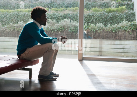 Man sitting on a couch and thinking Stock Photo