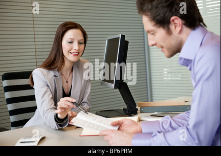 Female real estate agent showing a brochure to a man