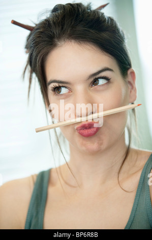 Woman balancing a pencil on lip Stock Photo - Alamy