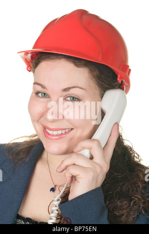 Young beautiful woman in red hard hat calling by phone. Isolated on white background Stock Photo