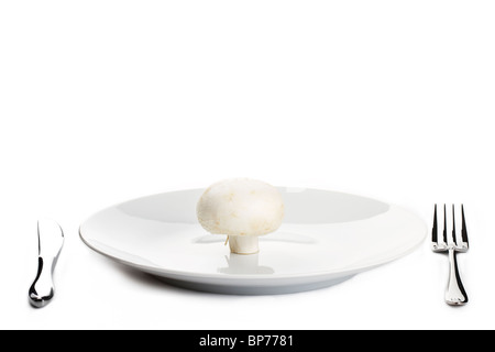 one white mushroom on a plate with knife and fork Stock Photo