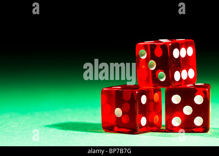 three red dices on green table and black background Stock Photo