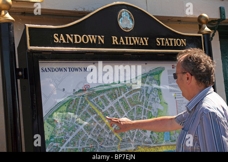 Man checking the Sandown Town map at Sandown Railway Station, Isle of Wight, Hampshire UK in June Stock Photo