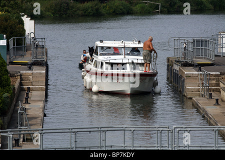 man on a boat going into a lock on the River Thames, Goring and Streatley West Berkshire Stock Photo