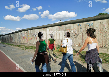 Tourists passing by the remains of the former Berlin Wall, Berlin, Germany Stock Photo