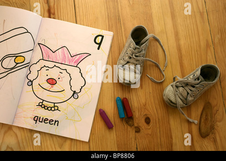 Child's colouring book, crayons and shoes Stock Photo