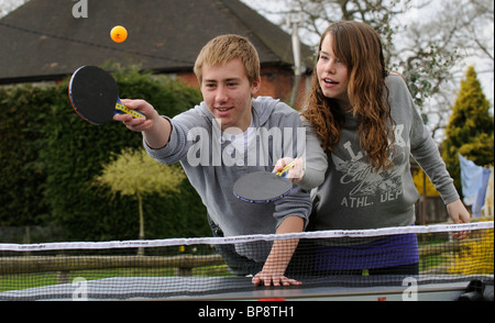 Young boy and girl playing table tennis Stock Photo