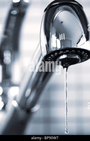 Water dripping from stainless steel kitchen faucet Stock Photo