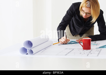 female architect drawing on blueprint Stock Photo