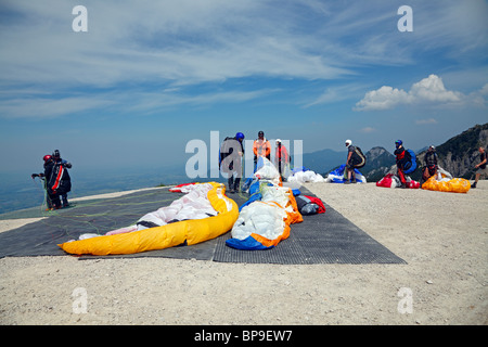 Queue of paragliders ready for take-off in the right wind conditions from the summit of Tegelberg in Schwangau, Bavaria, Germany Stock Photo