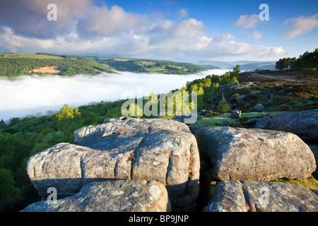 Froggatt edge at first light on May morning with mist filling the valley Stock Photo