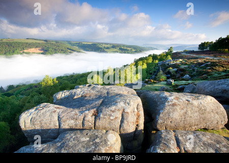 Froggatt edge at first light on May morning with mist filling the valley Stock Photo