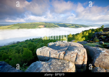 Froggatt edge at first light on May morning with mist filling the valley Stock Photo