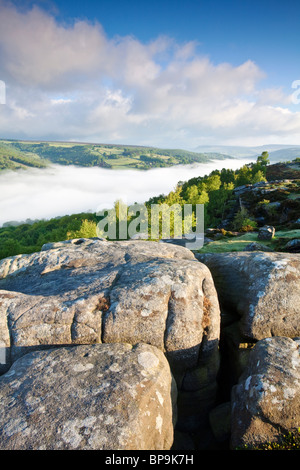 Froggatt edge at first light on May morning with mist filling the valley Stock Photo