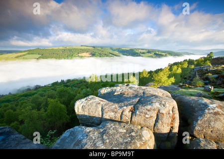 Froggatt edge at first light on May morning with mist filling the valley Stock Photo