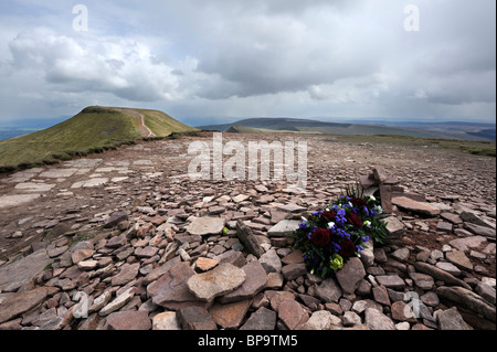 Flowers laid upon the summit cairn of Corn Du in the Brecon Beacons, Wales. Stock Photo