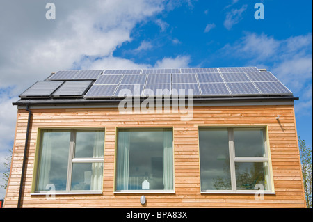 Timber clad zero carbon passive house with triple glazed windows & roof covered with solar panels for electricity and hot water Stock Photo