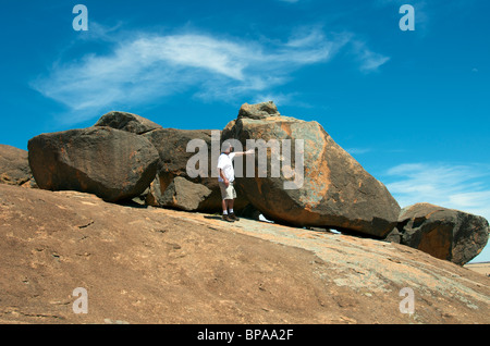Man examining Tafoni on Kings Rocks near Hyden Western Australia Stock Photo