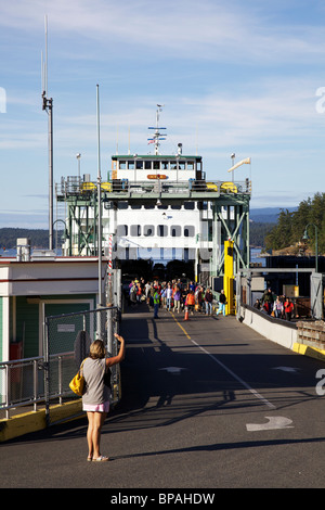 Woman greeting walk-on passengers disembarking from ferry. Friday Harbor, San Juan Island, Washington. Stock Photo