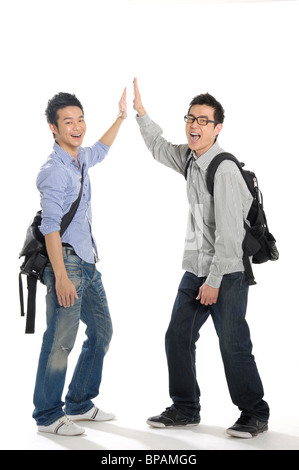 Male university students giving high-five to each other Stock Photo