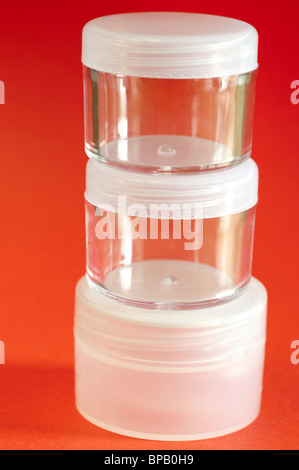 Three small plastic stacked cosmetic containers with screw tops Stock Photo