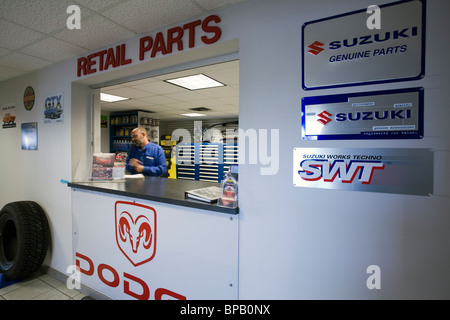 Parts department window in a dealership that sells Dodge and Suzuki cars and trucks. Stock Photo