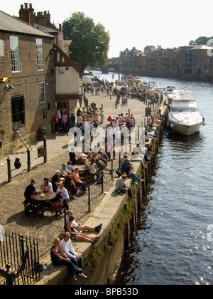The riverbank at Kings Staith packed with people enjoying the summer sunshine. York River Ouse. Stock Photo