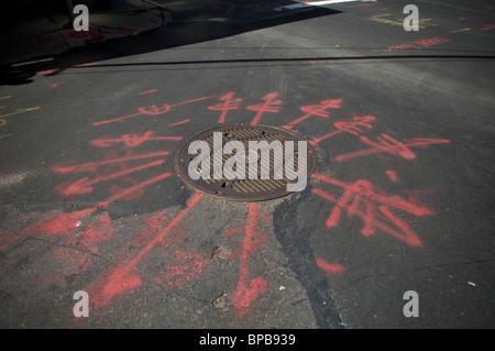 A manhole cover protecting electrical cables with surveyor's marks in New York Stock Photo