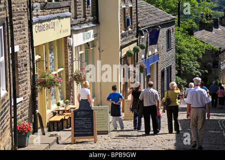 Visitors on cobbled Main Street in Haworth, West Yorkshire, England, UK. Stock Photo