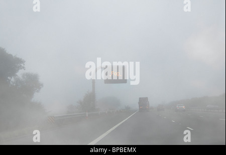 Variable message sign warning drivers of fog on a foggy UK motorway Stock Photo