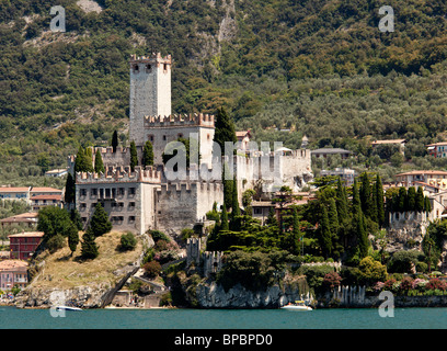 Power boat off the coast of Malcesine on Lake Garda with the castle framing the town Stock Photo