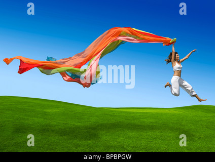 Athletic woman jumping on a green meadow Stock Photo
