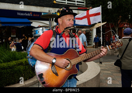 A one man band sings and plays in Warrington Town Centre during their historic car event Stock Photo