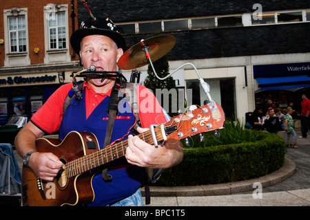 A one man band sings and plays in Warrington Town Centre during their historic car event Stock Photo