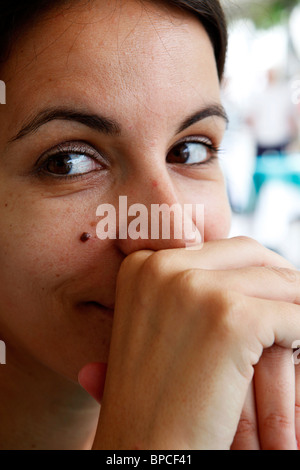 A young woman sits and looks happy . Stock Photo