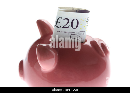 pink piggy bank with 20 pound note on white background Stock Photo