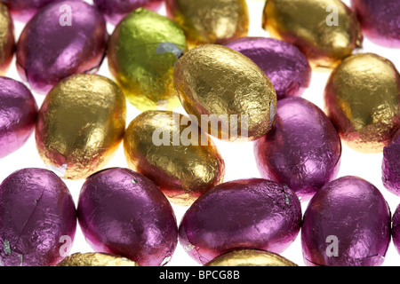 small foil wrapped chocolate easter eggs on white Stock Photo
