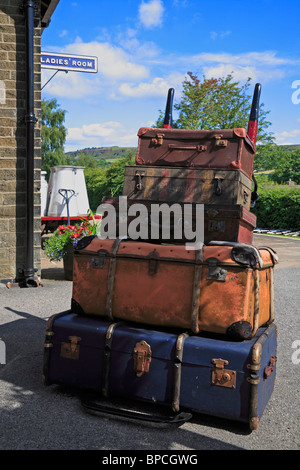 Old suitcases on a porters trolley at Oakworth Railway Station, Keighley and Worth Valley Railway, Oakworth, West Yorkshire, England, UK. Stock Photo