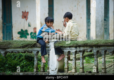 Two young boys play checkers on a wall near Sapa in northern Vietnam. Stock Photo