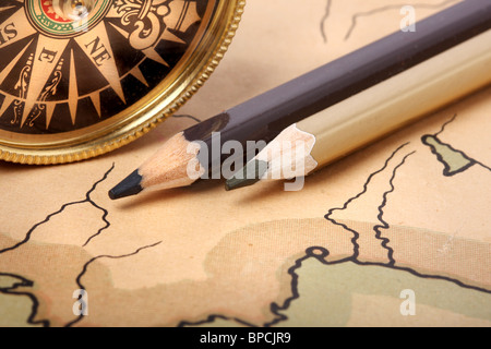 Compass and pencils on old contoured map, shallow DOF Stock Photo