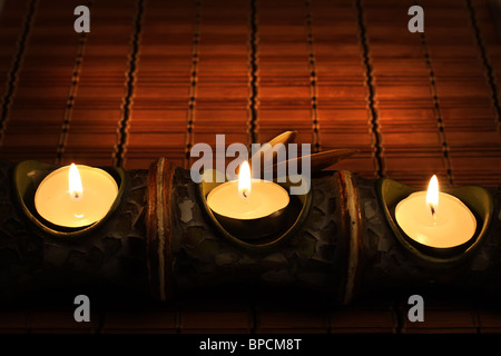Candles on bamboo rug in the dark Stock Photo